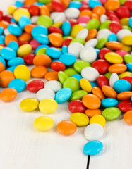 Colorful candies on white wooden background