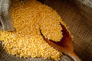 Raw moong dhal in jute bag and wooden scoup