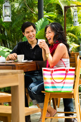 Asian man and woman in restaurant or cafe