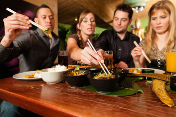 Young people eating in Thai restaurant