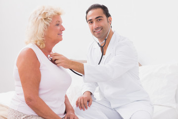 Smiling doctor examining an old woman