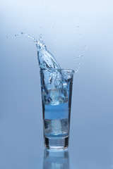 An ice cube falling into glass of water