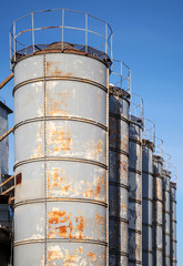 Rusted gray tall tanks on old factory