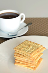Close-up of cream cracker cookie and hot coffee