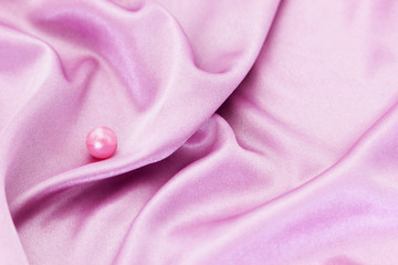 Obraz na płótnie Canvas Lilac silk fabric and pink bead