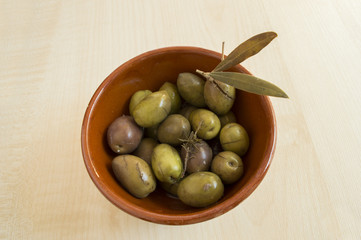 green spanish olives in a ceramic container