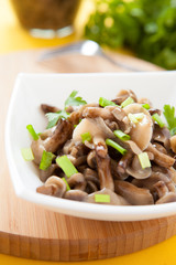 pickled honey agarics and green onions in a white bowl