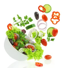 Crédence en verre imprimé Légumes Légumes frais mélangés tombant dans un bol de salade