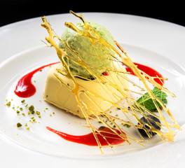 Ice cream decorated with spun sugar, mint leaf and sauce