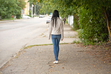 Fototapeta premium girl goes on city street in the autumn afternoon