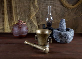 Still-life with mortars and an oil lamp on an old table