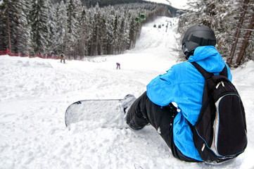 Fototapeta na wymiar Widok z tyłu sportowca z snowboardu patrzy na trudne