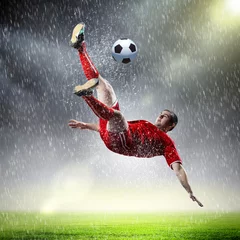 Abwaschbare Fototapete Fußball Fußballspieler, der den Ball schlägt