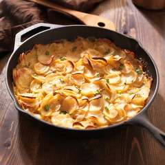 scalloped potatoes in rustic iron skillet
