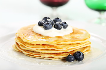 pancakes con mirtilli yogurt e miele su piatto