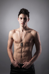 Obraz premium Muscular built man with a dog tags.