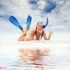Happy woman with snorkeling equipment on the beach