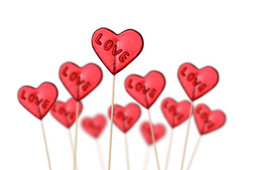 Fototapeta na wymiar Red heart shaped lollipops on white background.