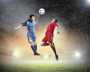 two football players striking the ball