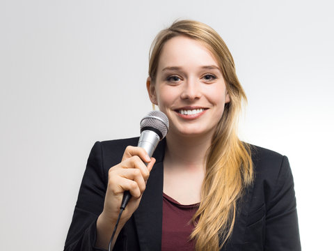 Junge Frau singt ins Mikrofon