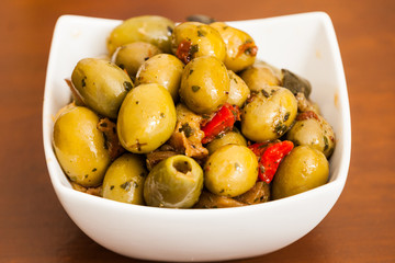 Varitey of olives into into bowls on wooden table 