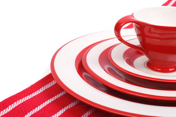 Table setting. Red crockery for striped napkin isolated