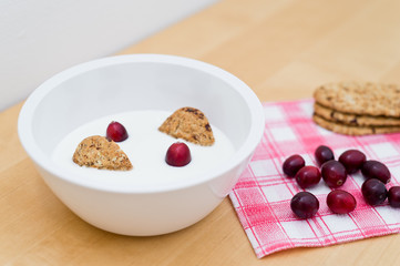 Breakfast containing yogurt, cereal biscuits and cranberries