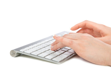 Hands typing on the remote wireless computer keyboard
