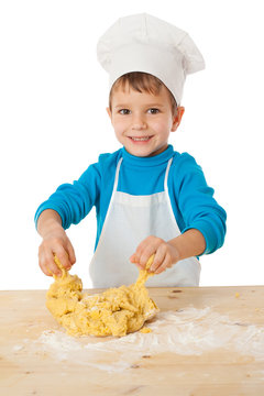 Little boy kneading the dough