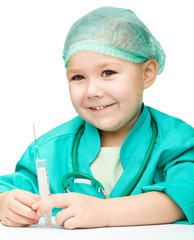 Cute little girl is playing doctor with syringe