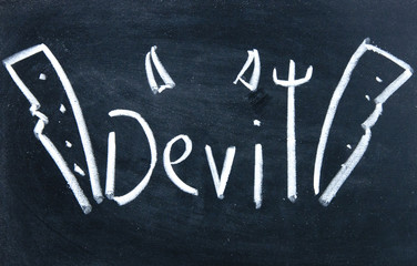 devil sign drawn with chalk on blackboard