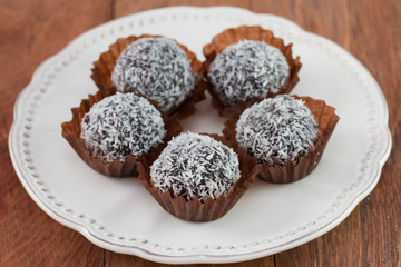 chocolate truffles with coconut on the white plate