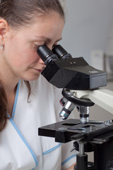 Young female doctor with microscope