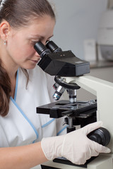 Young female doctor with microscope