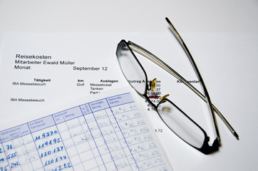 Reisekostenabrechnung mit Brille und Fahrtenbuch
