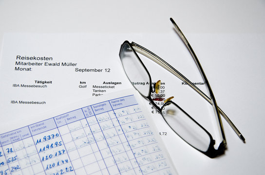 Reisekostenabrechnung mit Brille und Fahrtenbuch