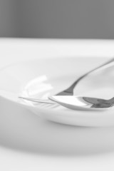 Plate, spoon, fork on a white background