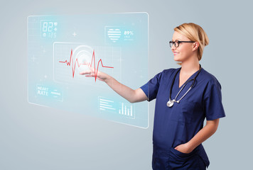 Young nurse pressing modern medical type of buttons