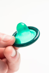 Hand holding green condom