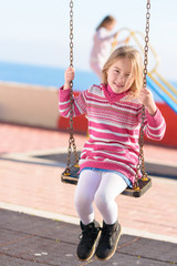 Blonde Girl Swinging In Playground
