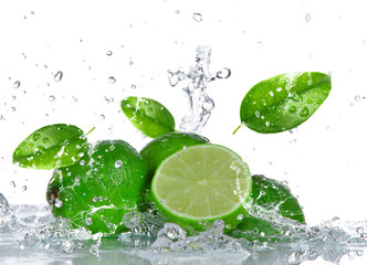 Limes with water splash isolated on white