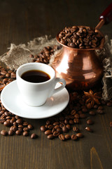 Cup of coffee and pot on wooden background