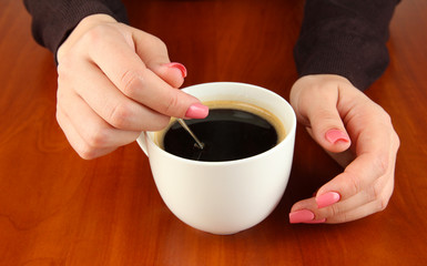 Hands holding mug of hot drink, close-up