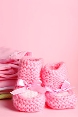 Pile of baby clothes on pink background