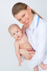 Happy smiling pediatrician/ therapist woman holding lovely child