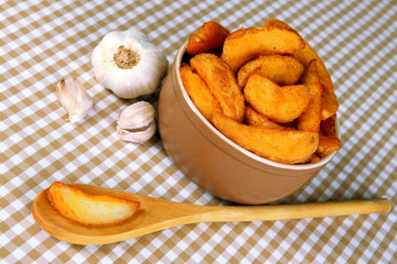 Appetizing village potatoes in bowl on beige tablecloth