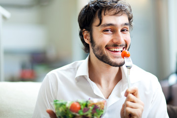 Happy man eating a salad