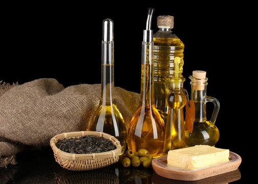 Different types of oil with sunflower seeds and olives