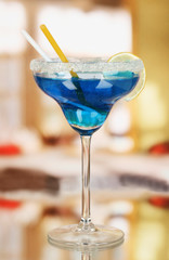 Blue cocktail in glass on room background