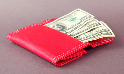 Purse with hundred dollar banknotes, on color background